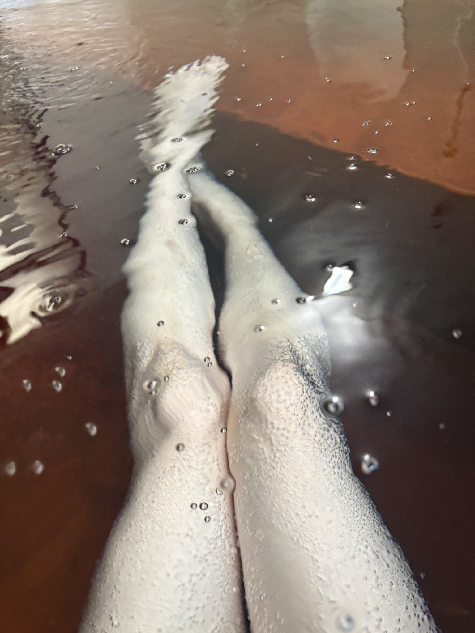 炭酸泉に浸かる両脚 - 気泡が全体を包む ©mofoko18